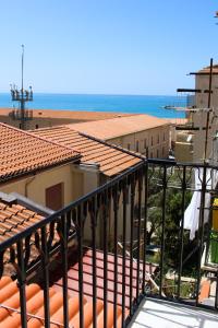Elle comprend un balcon offrant une vue sur un bâtiment et l'océan. dans l'établissement Casa don Luigi, à Cefalù