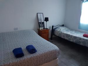sypialnia z 2 łóżkami i niebieskimi ręcznikami w obiekcie Casa Somnis Alta Gracia w mieście Alta Gracia