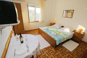 a small bedroom with a bed and a tv at Apartments Vera - 150 m from sea in Sukošan