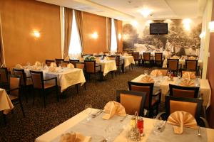 una sala da pranzo con tavoli e sedie bianchi di Hotel Crystal a Sarajevo