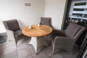 a wooden table with chairs and a coffeeucer on it at Premium Apartment München Messe in Munich