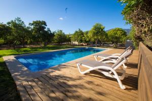 um deque com 2 espreguiçadeiras ao lado de uma piscina em Cabañas La Luz em Olmué