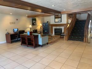 ein Wohnzimmer mit einem Schreibtisch und einer Treppe in der Unterkunft Country Inn & Suites by Radisson, West Valley City, UT in West Valley City