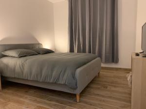 Schlafzimmer mit einem Bett und einem Fenster mit Vorhängen in der Unterkunft Appartement Cosy Jacuzzy Luxe Gare de Toulon in Toulon