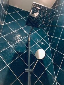 a blue tiled bathroom with a shower with a light at Central Luxury Louvre Opera 3rd Floor in Paris