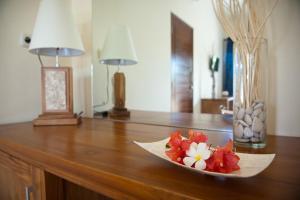 a bowl of flowers sitting on top of a wooden table at Blue Marine Resort in Gili Air
