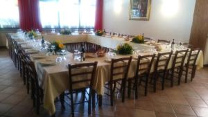 una lunga sala da pranzo con un lungo tavolo con sedie di Il Falco E La Volpe a Settimo Vittone