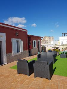 une terrasse avec des chaises et une cour avec une maison dans l'établissement Hotel Bela Vista, à Olhão