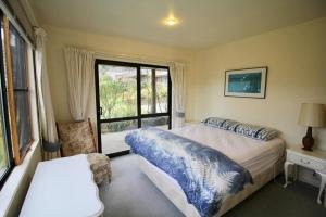a bedroom with a bed and a large window at 20 Bristol Street in Hanmer Springs