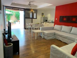 a living room with a couch and a tv and a kitchen at BTC Boutique Resort Private Pool Villas and Studios Hua Hin บ้านทะเลจีน บูติค รีสอร์ท หัวหิน in Hua Hin