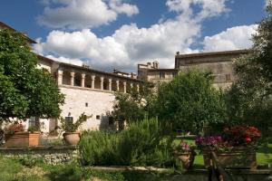 un patio de un edificio con plantas y flores en Le Logge Di Silvignano, en Campello sul Clitunno