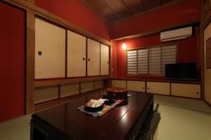 a kitchen with red walls and a table with food on it at 和美再美 石動 柏屋 Wabisabi Isurugi Kashiwaya in Oyabe