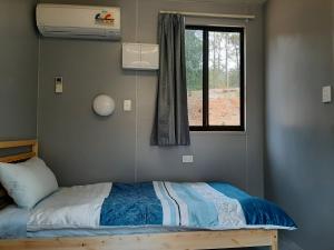 a small bedroom with a bed with a window at Springwood Meditation Centre 春木禪修渡假中心 in Springwood