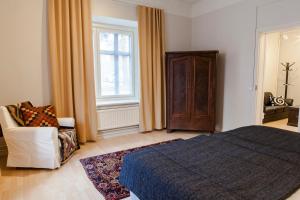 een slaapkamer met een bed, een stoel en een raam bij Hotelli Ville Apartment in Tampere