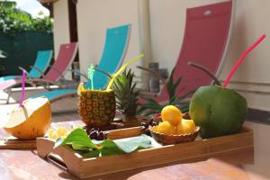 a wooden tray with fruit on top of a table at Villa Grenadine in Pointe-Noire