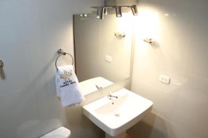 uma casa de banho branca com um lavatório e um espelho em Hotel Camino Real em Chimbote
