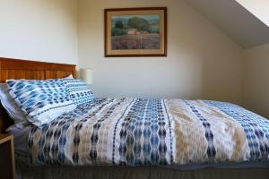 a bedroom with a bed and a picture on the wall at 12 Oregon Heights in Hanmer Springs