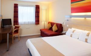 a hotel room with two beds and a television at Holiday Inn Express Cardiff Airport, an IHG Hotel in Rhoose