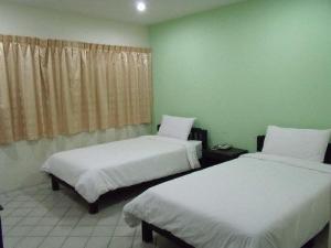 a room with two beds and a window at Life In Town Chiangmai in Chiang Mai