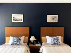 two beds in a room with blue walls at Tonwa Resort Hotel in Khon Kaen