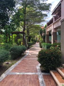 a walkway in front of a building with trees at Tonwa Resort Hotel in Khon Kaen