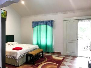 - une chambre avec un lit et un rideau vert dans l'établissement Bali Aman Darling House, à Canggu
