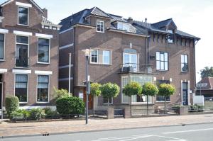 een groot bakstenen gebouw aan de kant van een straat bij City Hotel Koningsvlinder in Veenendaal