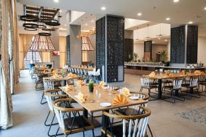 a dining room with wooden tables and chairs at H Elite Design Hotel in Kota Bharu