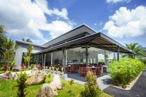 a house with a large roof with a patio at The La Valle'e Resort in Khao Lak