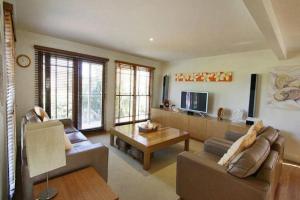 a living room with a couch and a table at Illalangi - views, pool, walk to beach in North Haven