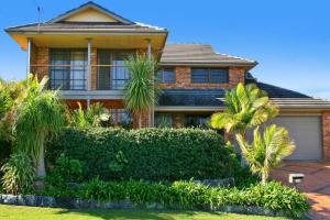 a house with palm trees in front of it at Illalangi - views, pool, walk to beach in North Haven