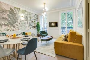 a living room with a yellow couch and a table and chairs at Stylish 2bd House in Central Paris by GuestReady in Paris