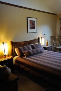 1 dormitorio con 1 cama con 2 lámparas en las mesas en Forest Walks Lodge en Jackeys Marsh