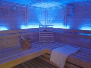 une chambre avec un banc dans une pièce avec des lumières bleues dans l'établissement Pension Walddorf, à Winterberg