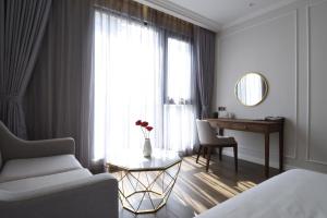 um quarto com uma cama, uma secretária e uma janela em Phu Cuong Hotel Ca Mau em Cà Mau