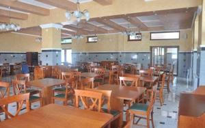 comedor con mesas y sillas de madera en Complex Domneasca, en Seimeni