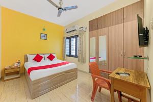 ein Schlafzimmer mit einem Bett, einem Tisch und einem Schreibtisch in der Unterkunft Sreedevi Residency in Chennai