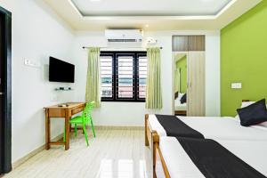 ein Hotelzimmer mit einem Bett und einem Schreibtisch in der Unterkunft Sreedevi Residency in Chennai