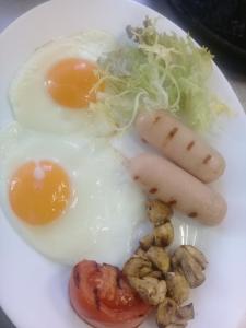 un plato de comida con huevos, salchichas y verduras en Gorny Ruchej, en Hora