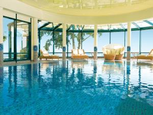 - une grande piscine avec des chaises dans un bâtiment dans l'établissement Travel Charme Strandhotel Bansin, à Bansin