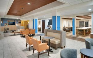 eine Lobby eines Krankenhauses mit Tischen und Stühlen in der Unterkunft Holiday Inn Express & Suites American Fork - North Provo, an IHG Hotel in American Fork