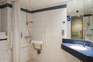 a bathroom with a sink and a shower at Holiday Inn Express Portsmouth Gunwharf Quays, an IHG Hotel in Portsmouth