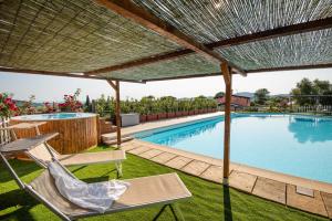 a patio with a chair and a swimming pool at Agriturismo Borgo Campetroso in Suvereto