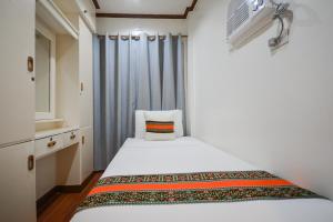 ボラカイにあるSur Beach Resort Boracayの小さなベッドルーム(白いベッド1台、窓付)