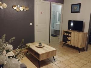 a living room with a coffee table and a television at Caroline in Oyonnax