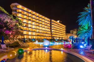 ein großes Gebäude mit Swimmingpool in der Nacht in der Unterkunft Izu Imaihama Tokyu Hotel in Kawazu