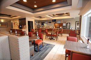 a restaurant with tables and chairs and a bar at Holiday Inn Express Hotel & Suites Ashland, an IHG Hotel in Ashland