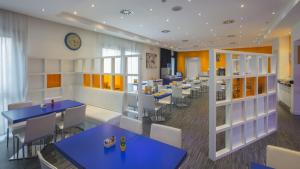 a restaurant with blue tables and chairs and a clock at GP Hotel in Rome