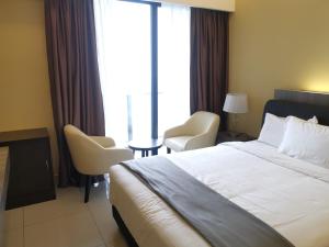 a hotel room with a bed and chairs and a window at Avanie Suite at Genting Highland in Genting Highlands +10 photos