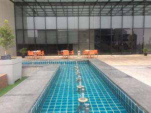 a swimming pool with tables and chairs in a building at Avanie Suite at Genting Highland in Genting Highlands